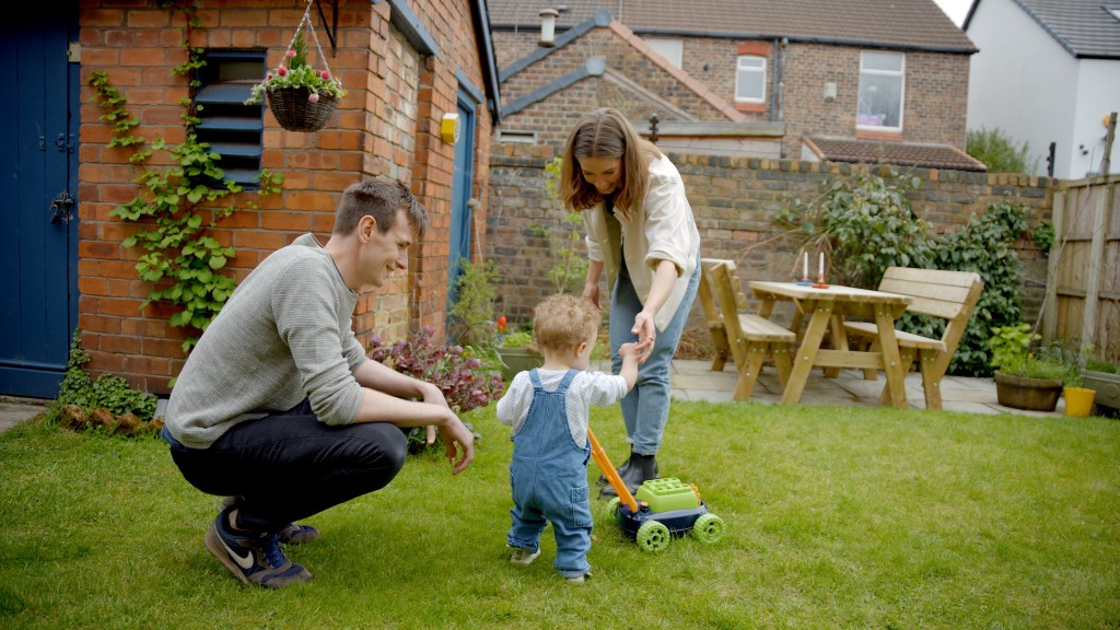 A couple and their child playing in the garden